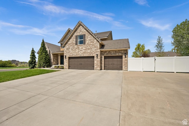 322 Flour Mill Dr, Kaysville, UT 84037 - view of front facade featuring a tile roof, concrete driveway, fence, a garage, and brick siding