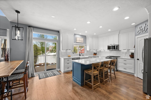 322 Flour Mill Dr, Kaysville, UT 84037 - kitchen featuring white cabinets, appliances with stainless steel finishes, light countertops, and light wood-style flooring