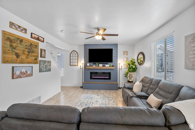 13137 S Acklins Dr, Herriman, UT 84096 - living area featuring visible vents, a ceiling fan, light wood-style floors, baseboards, and a fireplace
