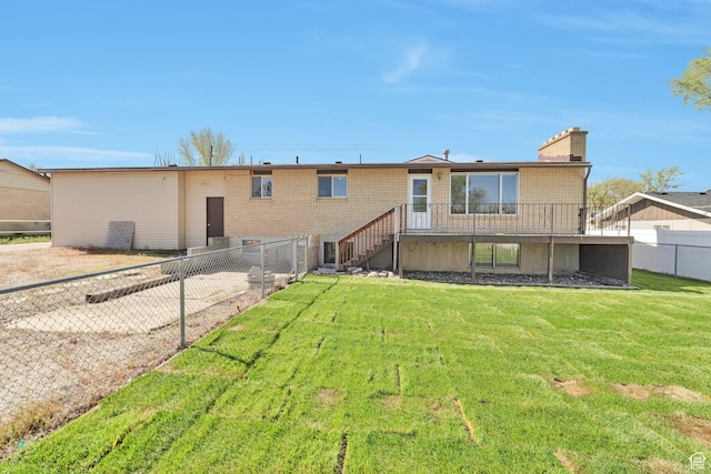 back of house with a fenced backyard, brick siding, stairs, and a lawn