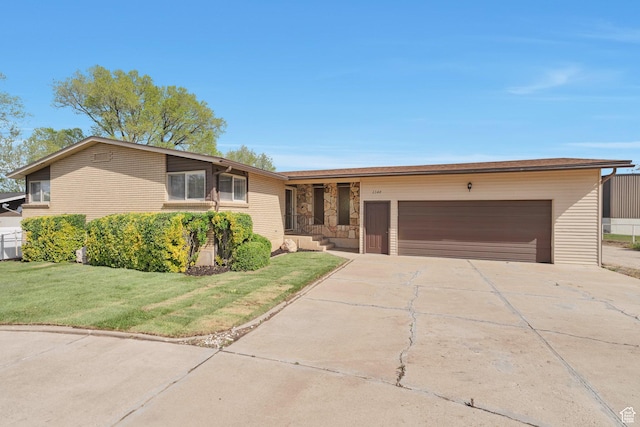 single story home with a garage, driveway, and a front yard
