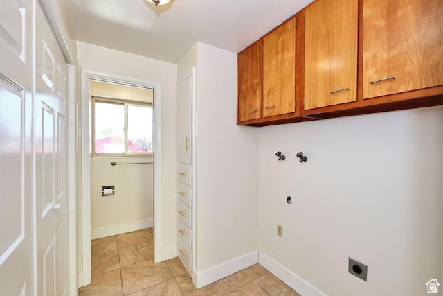 washroom featuring light tile patterned floors, hookup for an electric dryer, cabinet space, and baseboards
