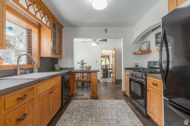 kitchen with dark countertops, open shelves, a sink, black appliances, and glass insert cabinets