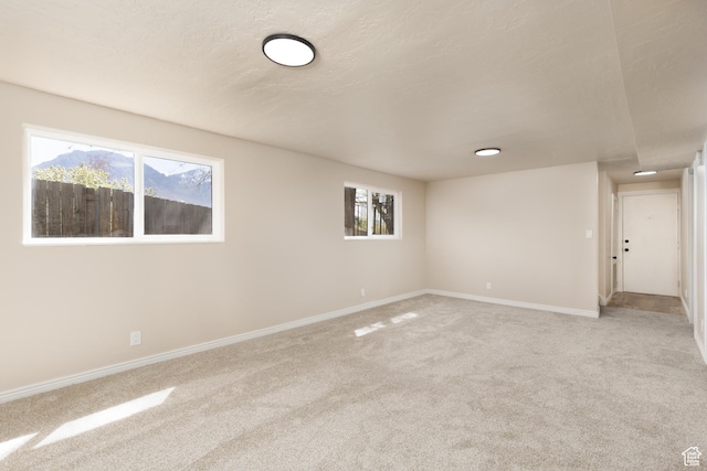 unfurnished room with baseboards and light colored carpet