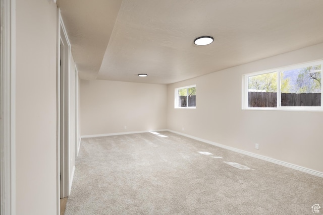 empty room featuring light carpet and baseboards