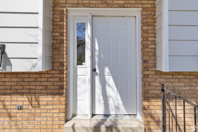 doorway to property featuring brick siding