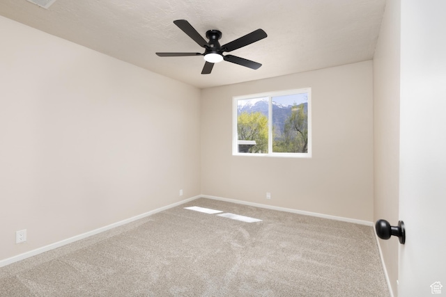 spare room featuring baseboards, carpet, and ceiling fan