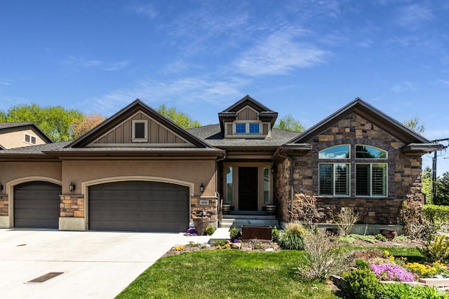 craftsman-style home with a garage, concrete driveway, stone siding, a front yard, and stucco siding