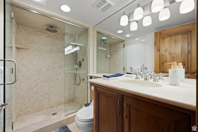 full bath with vanity, visible vents, a shower stall, and toilet