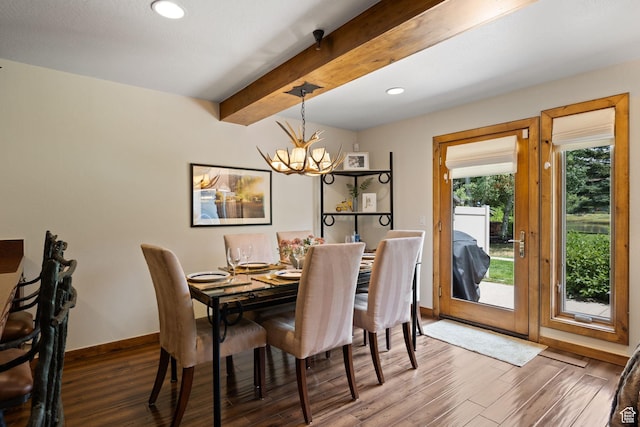 dining room with beamed ceiling, wood finished floors, baseboards, and an inviting chandelier