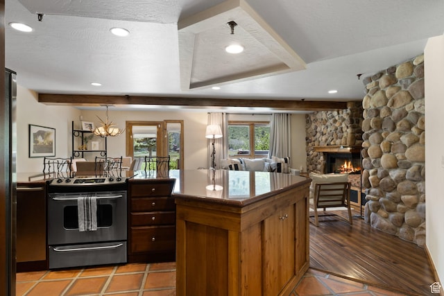 kitchen with recessed lighting, stainless steel electric range, beam ceiling, and a fireplace