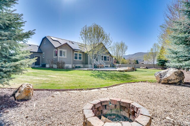 2520 S 260 E, Heber City, UT 84032 - rear view of property featuring a mountain view, a fire pit, solar panels, a patio area, and a lawn