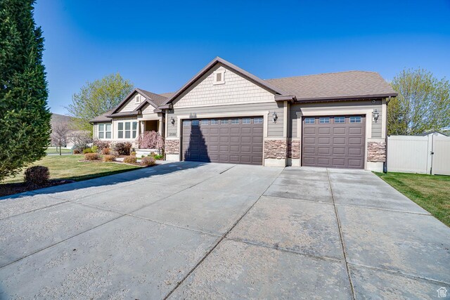 2520 S 260 E, Heber City, UT 84032 - view of front facade with a front lawn, a gate, stone siding, concrete driveway, and a garage