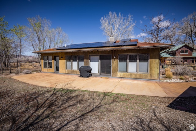 674 E Dragon Fly Trl, Moab, UT 84532 - rear view of house featuring roof mounted solar panels, a patio area, and metal roof