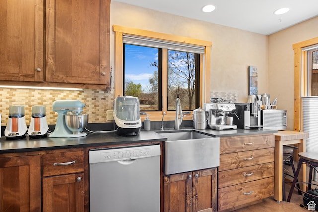 674 E Dragon Fly Trl, Moab, UT 84532 - kitchen featuring brown cabinets, a healthy amount of sunlight, dark countertops, and dishwashing machine