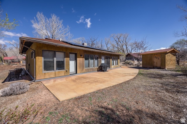 674 E Dragon Fly Trl, Moab, UT 84532 - rear view of property featuring solar panels, an outbuilding, a patio, and a storage shed