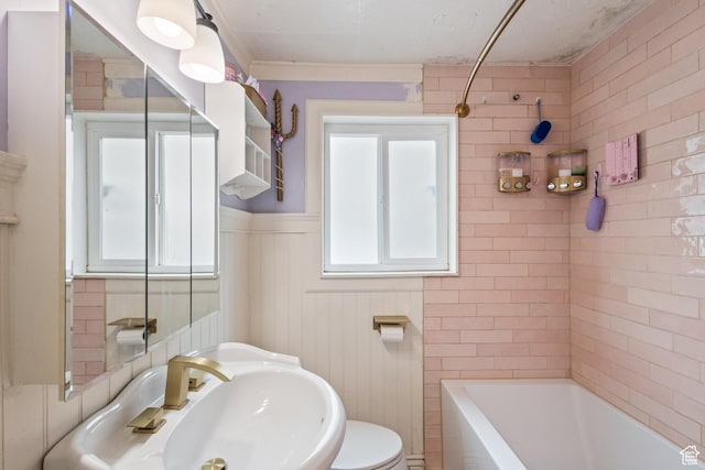 bathroom featuring a wainscoted wall, a sink, and toilet
