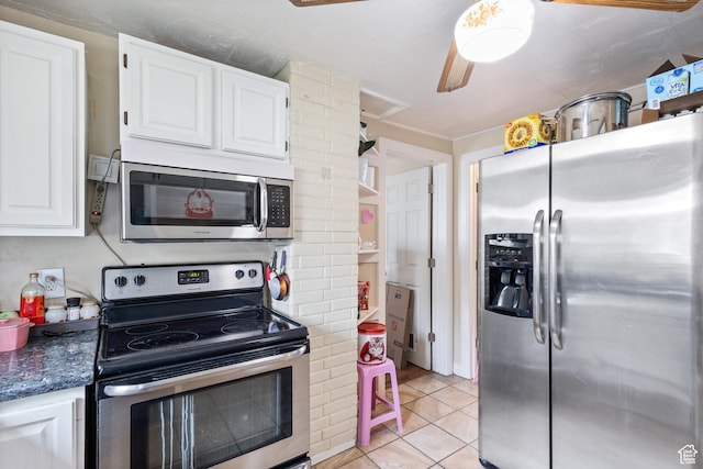 kitchen with white cabinets, light tile patterned floors, stainless steel appliances, and decorative columns