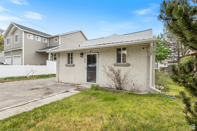 rear view of property featuring stucco siding, a yard, a patio, and fence