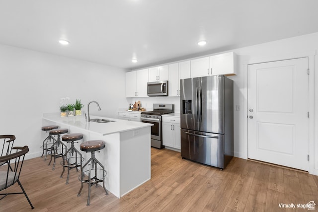 580 Hal St, Stansbury Park, UT 84074 - kitchen with a breakfast bar, white cabinets, stainless steel appliances, and a peninsula