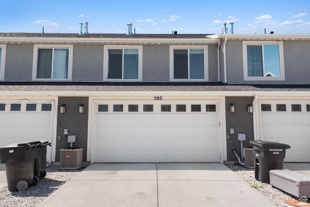 580 Hal St, Stansbury Park, UT 84074 - view of front of home with stucco siding, driveway, cooling unit, and a garage