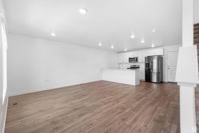580 Hal St, Stansbury Park, UT 84074 - unfurnished living room with recessed lighting, stairs, and wood finished floors
