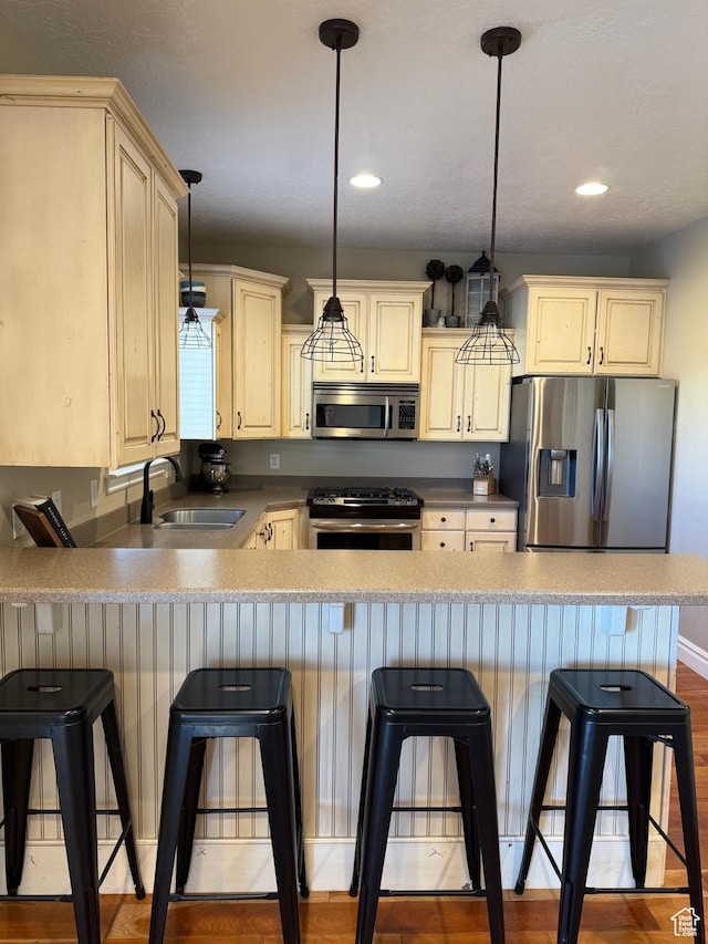 175 N 900 W, Roosevelt, UT 84066 - kitchen with a sink, pendant lighting, a peninsula, appliances with stainless steel finishes, and cream cabinets