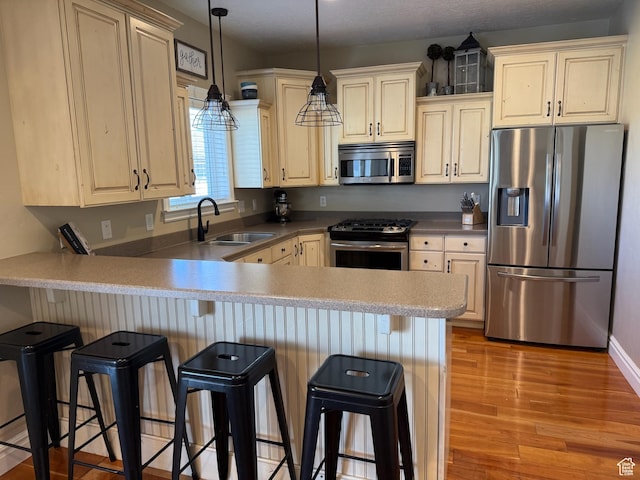 175 N 900 W, Roosevelt, UT 84066 - kitchen featuring a peninsula, a kitchen breakfast bar, a sink, light wood-style floors, and appliances with stainless steel finishes