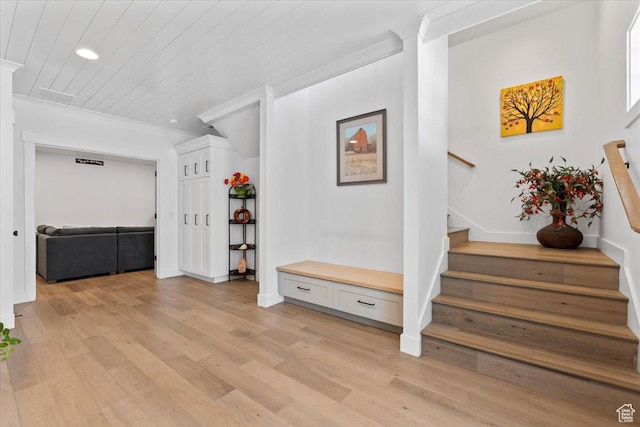 interior space with light wood-style floors, stairway, and crown molding