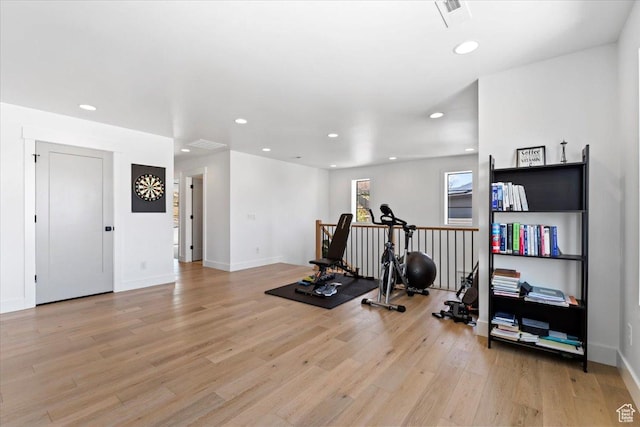 workout room featuring light wood finished floors, baseboards, and recessed lighting