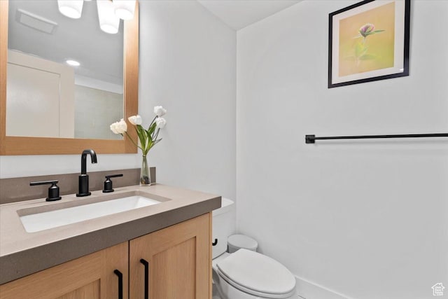 bathroom with visible vents, toilet, and vanity