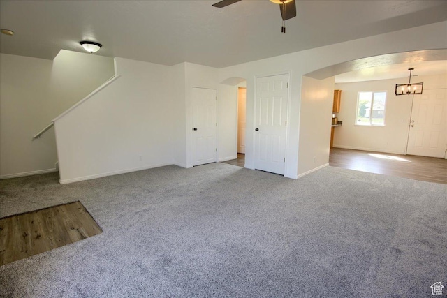 691 N Gramercy Ave, Ogden, UT 84404 - unfurnished living room with ceiling fan with notable chandelier, carpet, baseboards, and arched walkways