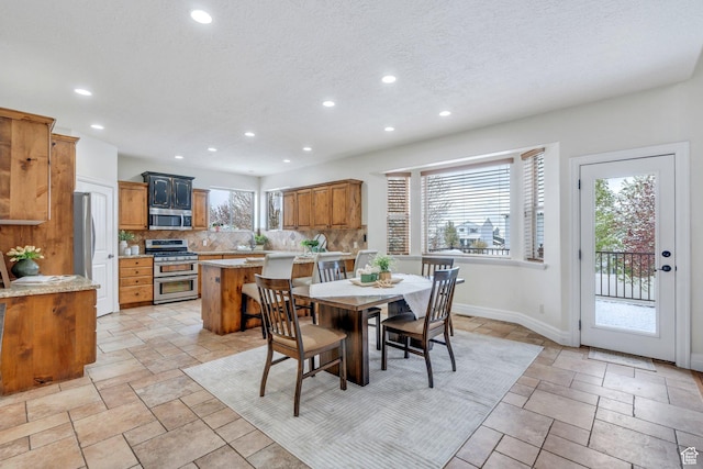 dining area featuring recessed lighting, stone tile floors, and baseboards