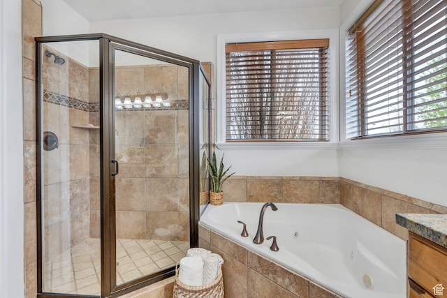 full bathroom with a shower stall, vanity, and a jetted tub