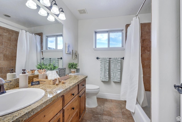 bathroom with toilet, visible vents, shower / tub combo, stone finish floor, and vanity