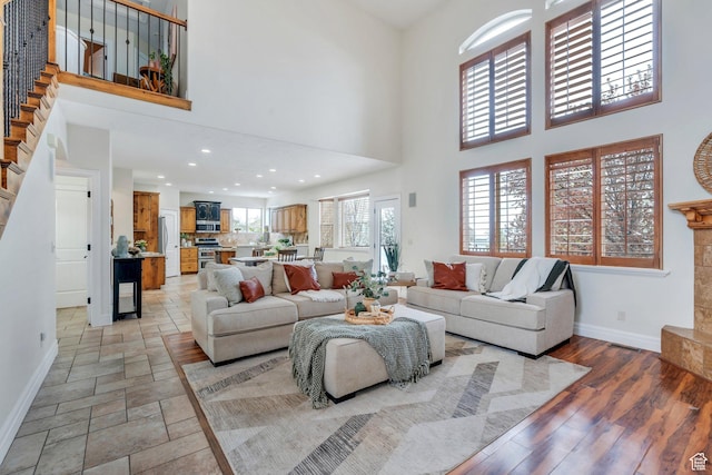 living area with baseboards, visible vents, and a high ceiling