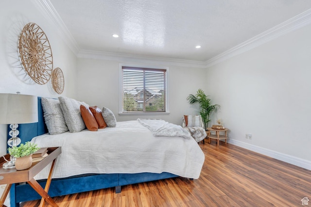 bedroom with baseboards, ornamental molding, wood finished floors, and recessed lighting