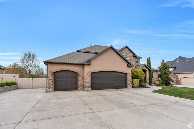 985 W Sunrise Ln, American Fork, UT 84003 - french country inspired facade with stone siding, concrete driveway, fence, an attached garage, and stucco siding