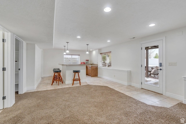 interior space with light colored carpet, recessed lighting, and light tile patterned floors