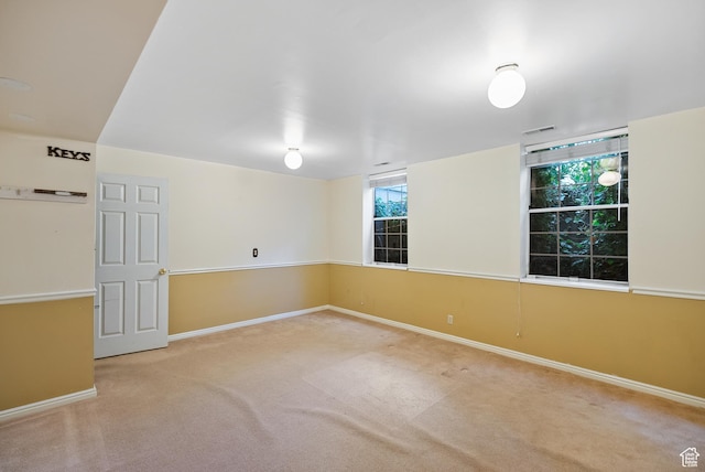 carpeted empty room with baseboards, visible vents, and a wealth of natural light