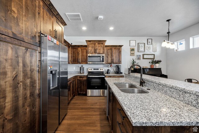 281 N 840 E, Hyrum, UT 84319 - kitchen with dark wood-style floors, light stone counters, stainless steel appliances, visible vents, and a sink