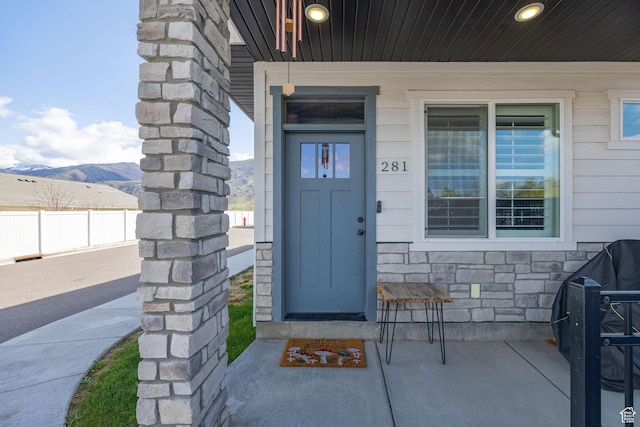 281 N 840 E, Hyrum, UT 84319 - view of exterior entry with covered porch, stone siding, fence, and a mountain view