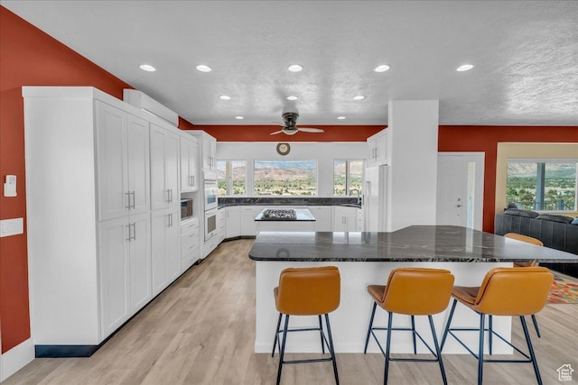 458 E Homespun Cir, Leeds, UT 84746 - kitchen with a center island, white refrigerator, recessed lighting, and a kitchen breakfast bar