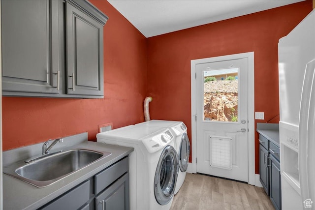 458 E Homespun Cir, Leeds, UT 84746 - clothes washing area featuring cabinet space, independent washer and dryer, light wood finished floors, and a sink