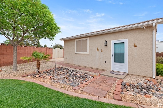 rear view of property featuring stucco siding and fence