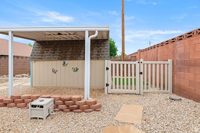 view of patio / terrace with a gate, an outbuilding, a shed, and a fenced backyard