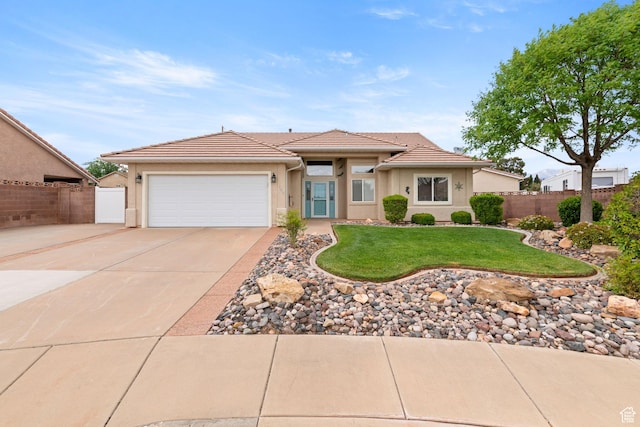 view of front of property featuring concrete driveway, a tiled roof, fence, a garage, and stucco siding