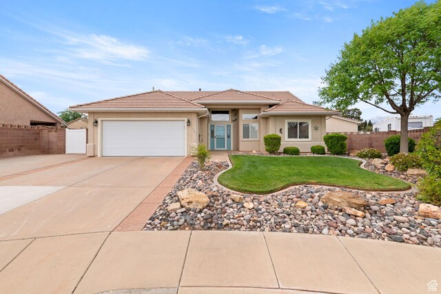 161 E 625th Cir S, Ivins, UT 84738 - view of front of property featuring concrete driveway, a tiled roof, fence, a garage, and stucco siding