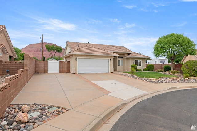 single story home with a tiled roof, a gate, driveway, fence, and a garage