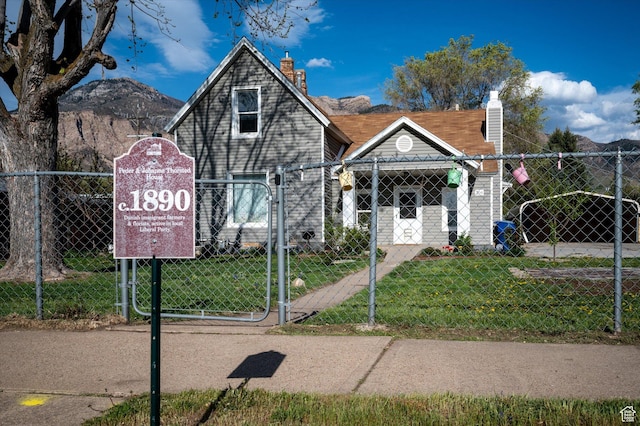 204 S 500 E, Ogden, UT 84404 - view of front facade featuring a front lawn, a chimney, a gate, and a fenced front yard